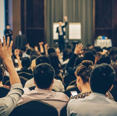 People Raising Hands at a Conference